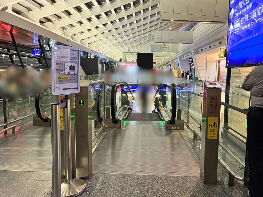 桃園空港　バス乗り場への道順　1階に降りるエスカレーター